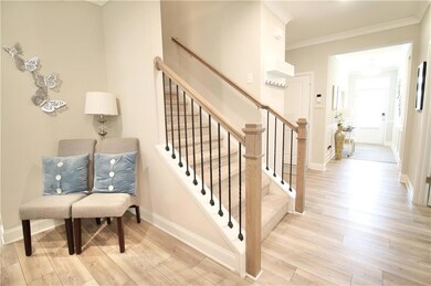 Stairway featuring wood finished floors and ornamental molding
