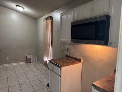 Kitchen featuring a textured ceiling, dark counter