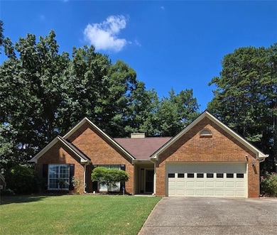 Single story home featuring concrete driveway, a garage, a front lawn, and brick siding