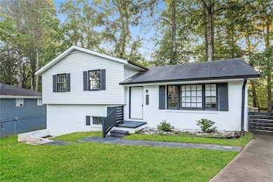 Tri-level home with a front yard and brick siding