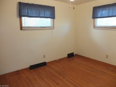 Bedroom 2 with hardwood flooring.