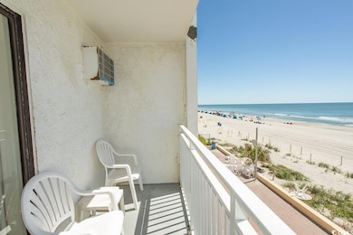 Balcony featuring a beach view and a water view