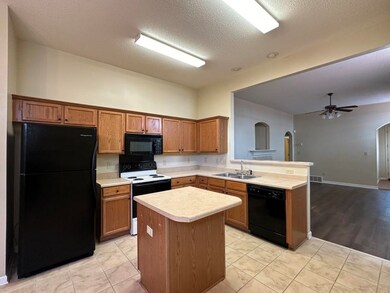 Kitchen featuring a textured ceiling, black applia