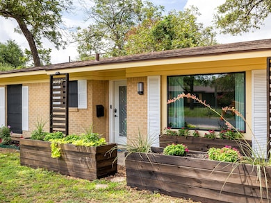 View of front facade with brick siding and a gard