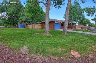 View of front of house with brick siding, a garage, and driveway