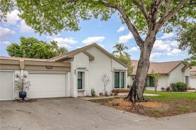 View of front of house featuring asphalt driveway,