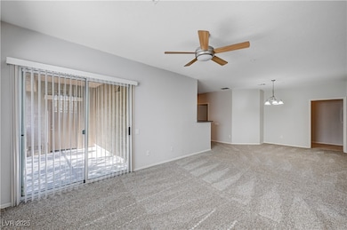Carpeted spare room featuring ceiling fan and a ch