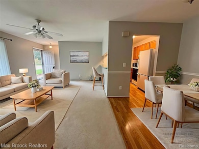 Living area with light wood-style floors and a ceiling fan