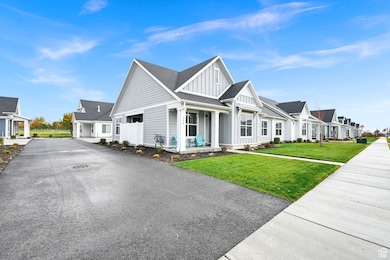 View of front facade with board and batten siding, a porch, a front lawn, and roof with shingles