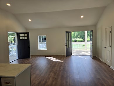 Entrance foyer featuring vaulted ceiling, recessed lighting, plenty of natural light, and dark wood-type flooring