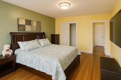 Bedroom with wood finished floors and a closet