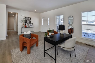 Office with wood finished floors and recessed lighting
