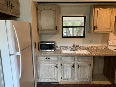 Kitchen with stove, sink, and white refrigerator