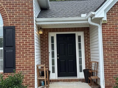 Entrance to property featuring brick siding and roof with shingles