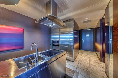 Kitchen with island exhaust hood, light marble finish floors, modern cabinets, stainless steel microwave, and black electric cooktop