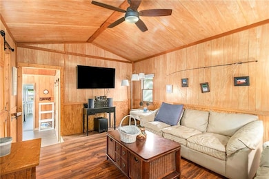 Living area featuring vaulted ceiling, a ceiling f