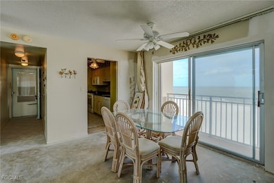 Dining room featuring a water view, a textured ceiling, and ceiling fan