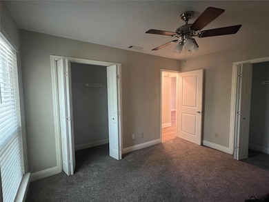 Unfurnished bedroom featuring dark carpet, basebo