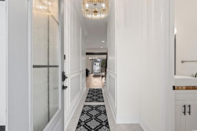 Corridor featuring a chandelier, crown molding, an