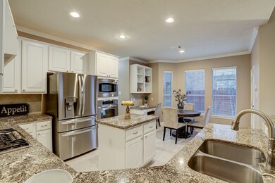 The cheery eat-in kitchen boasts gleaming granite countertops and on-trend white cabinetry centered by a prep island, for keeping everyone connected.
