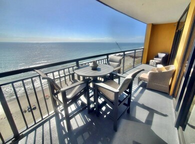 Balcony featuring a view of the beach and a water 