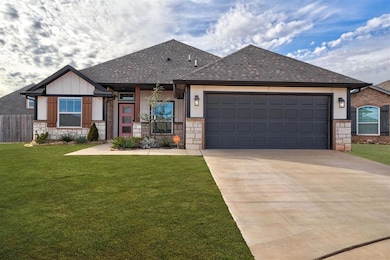 View of front of property featuring a garage and a front lawn