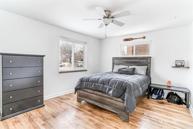 master bedroom has ceiling fan and front window.