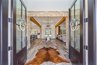 Foyer featuring a raised ceiling, wood-type floori