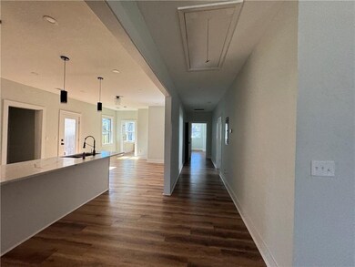 Hallway with attic access, baseboards, dark wood-t