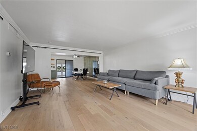 Living room with crown molding, light wood-type fl