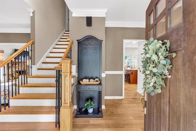 Staircase with crown molding, hardwood / wood-style flooring, and baseboards