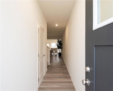 Corridor featuring light wood-type flooring and recessed lighting