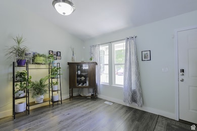 Interior space with wood finished floors and vaulted ceiling