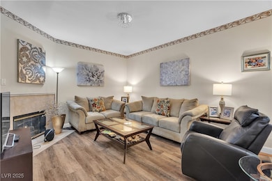 Living area with light wood-style flooring and a tiled fireplace