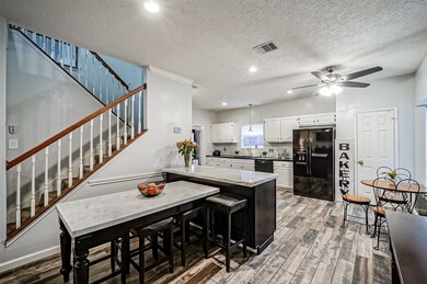 The family room makes a seamless transition to the updated kitchen, with this uniquely designed seated bar space that extends from the kitchen peninsula. Note the stylish black base and the gorgeous white quartz countertops.