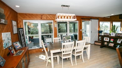 Dining space with wood walls, recessed lighting, and light wood-style floors