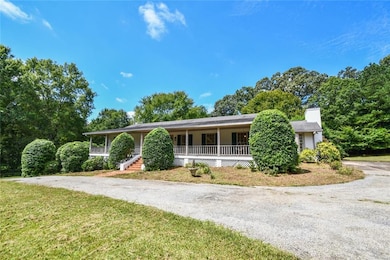 Ranch-style house with asphalt driveway, a porch, a chimney, and a front lawn