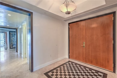 Entryway featuring baseboards and light tile patte