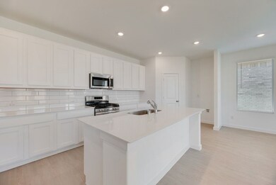 Kitchen featuring stainless steel appliances, tasteful backsplash, light wood finished floors, a center island with sink, and recessed lighting