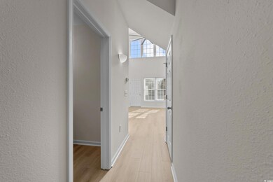 Hall with light hardwood / wood-style flooring and
