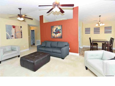 THE OPEN GREAT ROOM HAS VAULTED CEILINGS AND A COLORFUL ACCENT WALL.