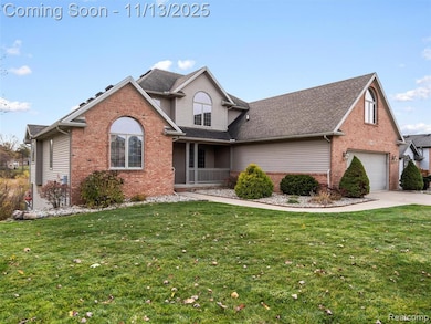 Traditional home with brick siding, a porch, a front lawn, and concrete driveway