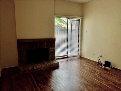 Cozy room with a brick fireplace and hardwood floo