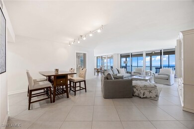 Living area featuring floor to ceiling windows, light tile patterned floors, and a water view