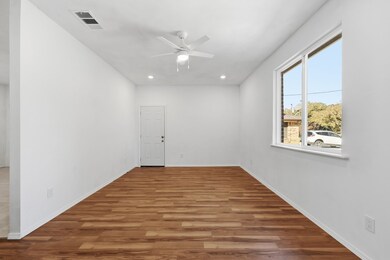 Large living room featuring light wood-type flooring, recessed lighting, and ceiling fan