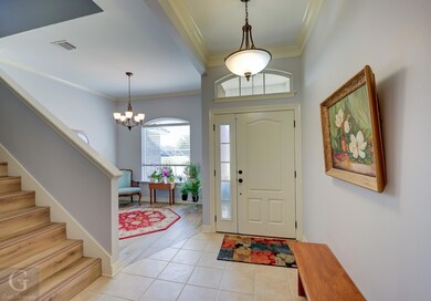 Foyer entrance featuring a notable chandelier, orn