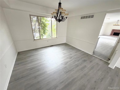 Unfurnished dining area with a chandelier and wood finished floors