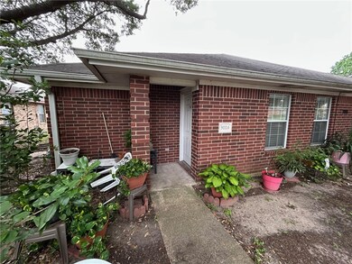 Doorway to property with brick siding and roof wit