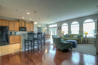 View of family room into kitchen with island, arched windows and french doors out to deck.