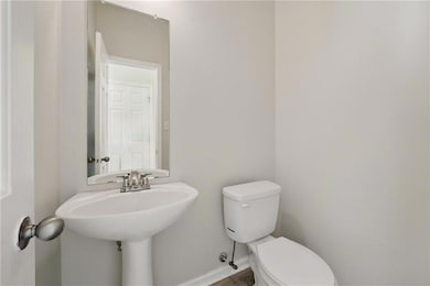 Bathroom with a sink, baseboards, and toilet